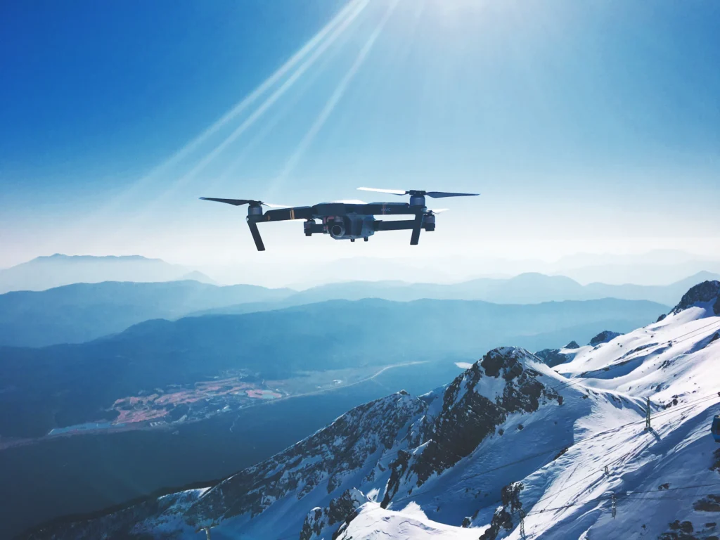 A multi-rotor drone gracefully gliding against a breathtaking backdrop of majestic mountains, exemplifying the versatility and scenic possibilities of drone technology.